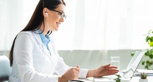 positive-doctor-in-earphones-having-online-consultation-with-patient-on-laptop-in-clinic-office.jpg